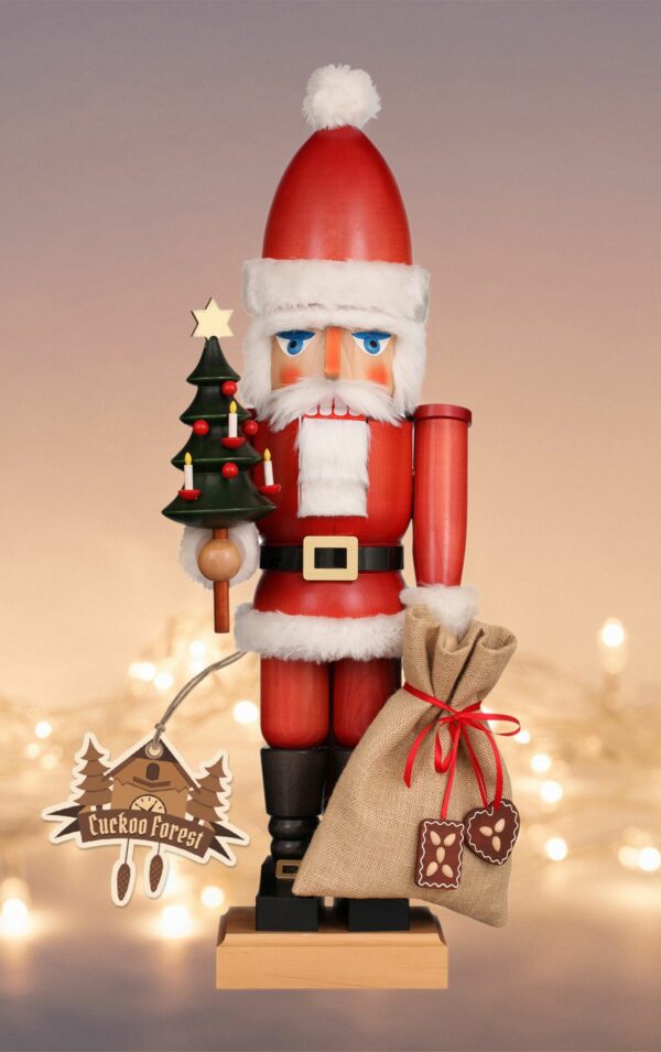 German Nutcracker Santa Claus in red holding Christmas tree and a bag of gifts